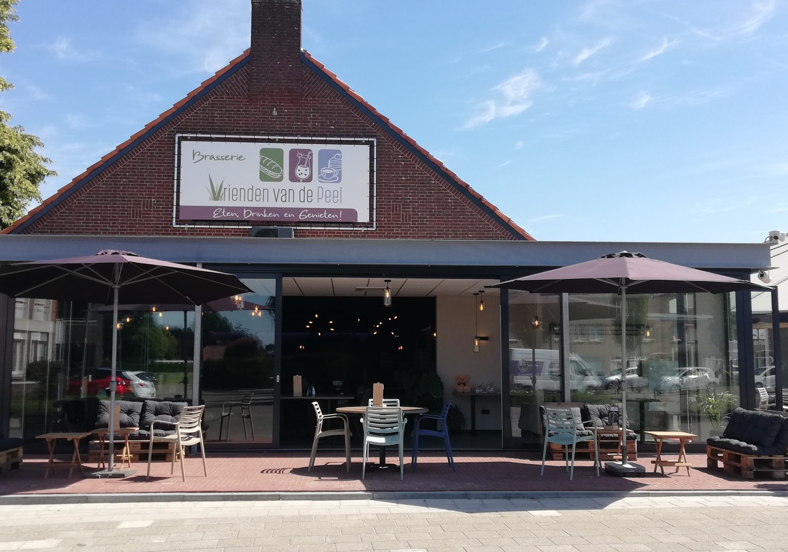 Voorgevel van Brasserie Vrienden van de Peel met terras en parasols