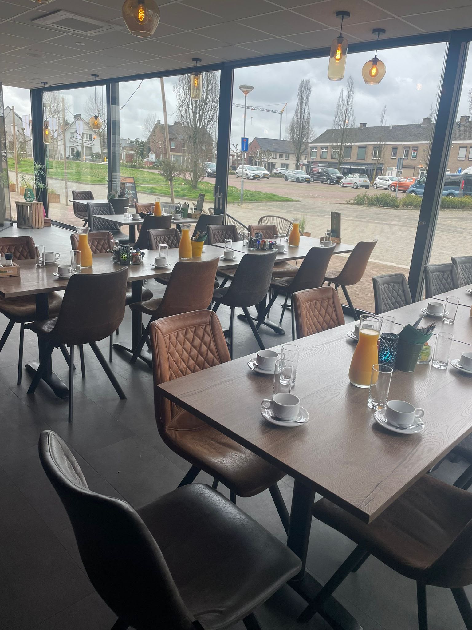 De brasserie met grote ramen en gedekte tafels